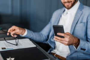 businessman typing out text on smartphone