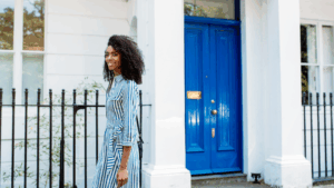 woman walking outside near a fence and house